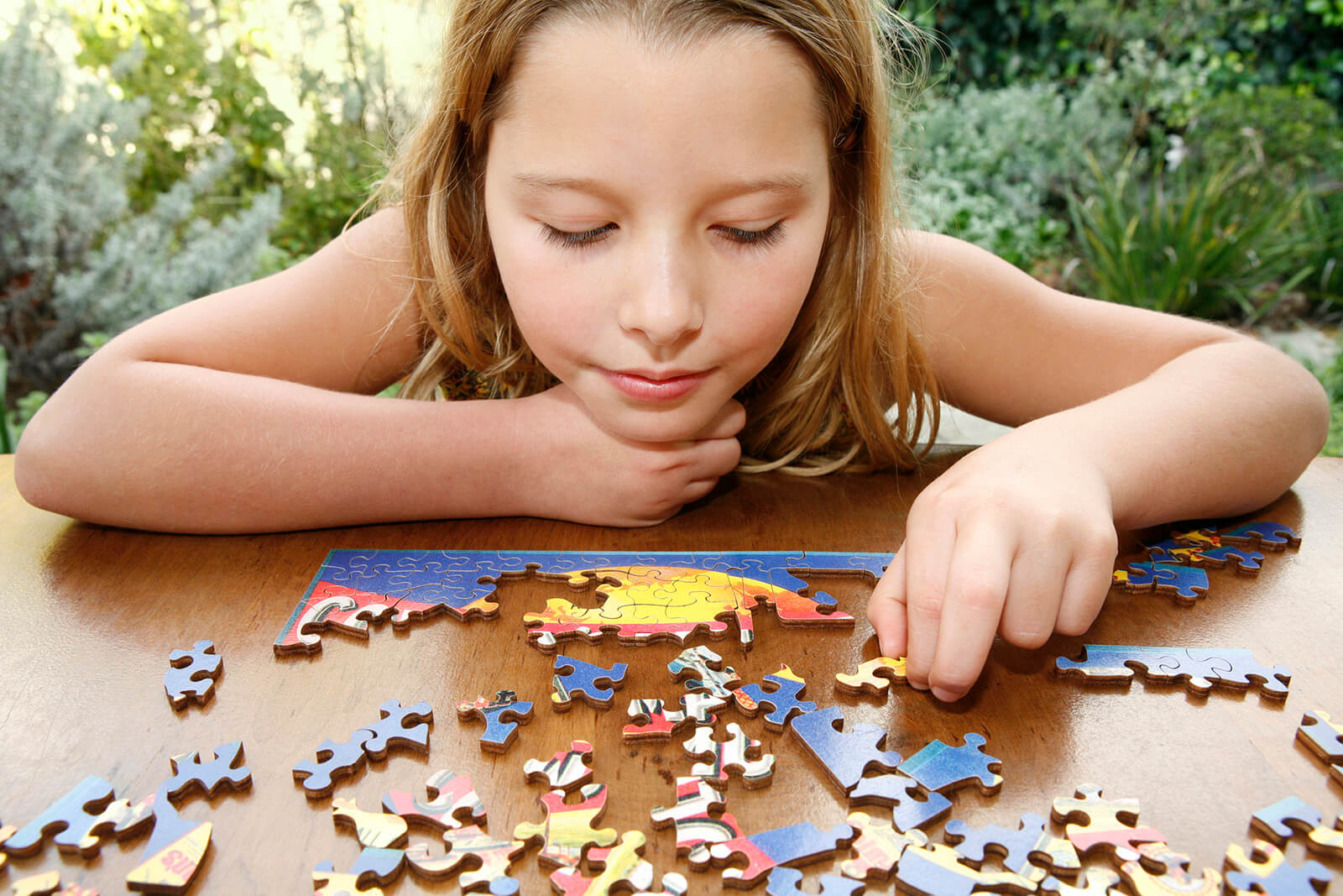 girl doing puzzle on wood table